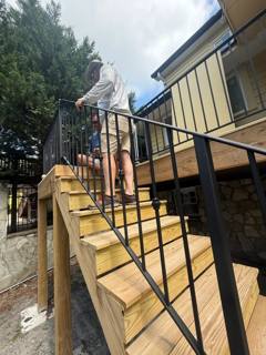 Horizontal-bar black railing on new timber exterior steps
