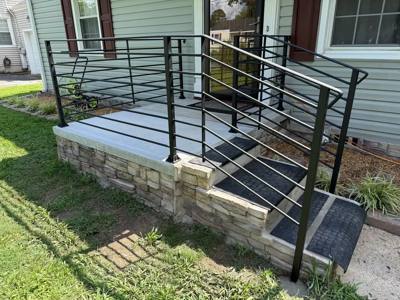 Horizontal black porch railing around a raised gray deck and steps