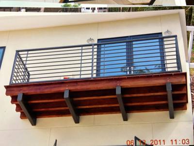 Horizontal black railing around an elevated wooden balcony