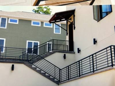Horizontal black railings following exterior stairs and an upper walkway