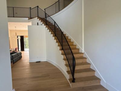 Interior curved staircase and upper gallery with matching black railings
