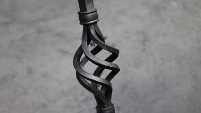 Open basket-shaped twist detail in a dark metal baluster