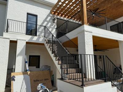 Outdoor black stair railings between stacked covered terraces