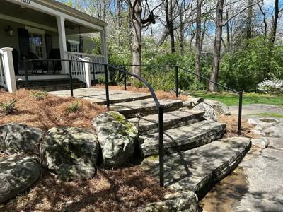 Plain black handrails beside large stone landscape steps