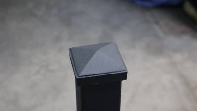 Pyramid-shaped cap on a square black railing post