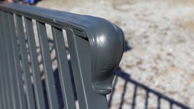 Rounded black handrail return at the end of a railing panel