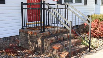 Side view of vertical-bar stair railings at a white-sided house