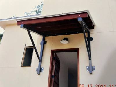 Small canopy above an entrance supported by black metal brackets