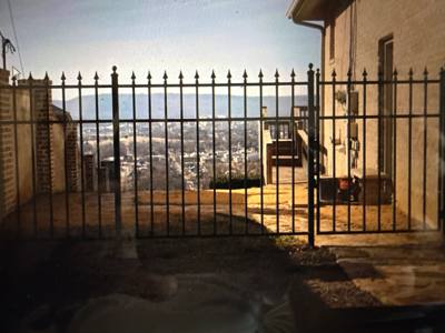 Spear-top gate and fence across a paved side passage