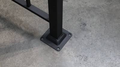 Square railing post and mounting plate on a workshop floor