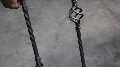 Twisted metal baluster beside an open basket ornament