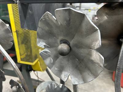 Unfinished flower-shaped metal ornament with curved petals