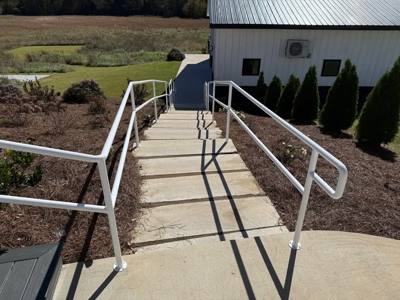 View down long concrete steps bordered by white handrails