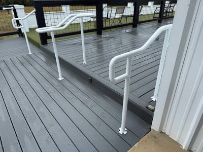 White double-level handrails beside a gray deck and steps