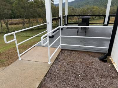 White handrails framing a deck entrance and short gray stairway