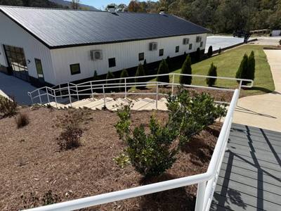 White handrails tracing exterior steps around a landscaped slope