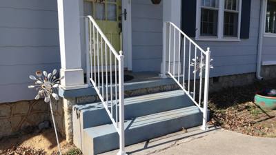 White railings with flower details beside three painted porch steps
